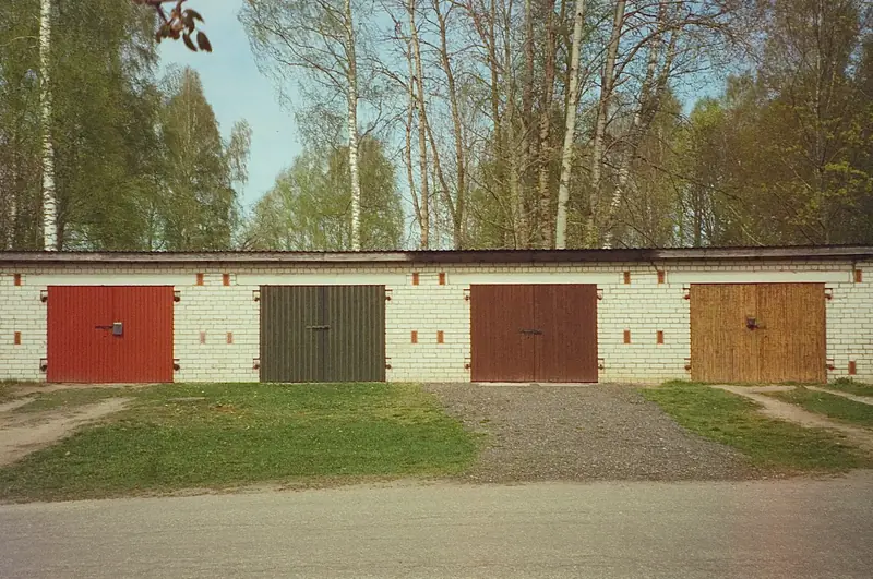 Reihengaragen aus Backstein mit Holz- und Blechtoren
